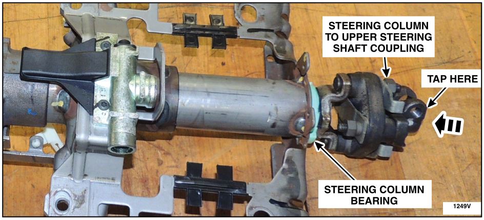 lightly tap the steering column to upper steering shaft coupling