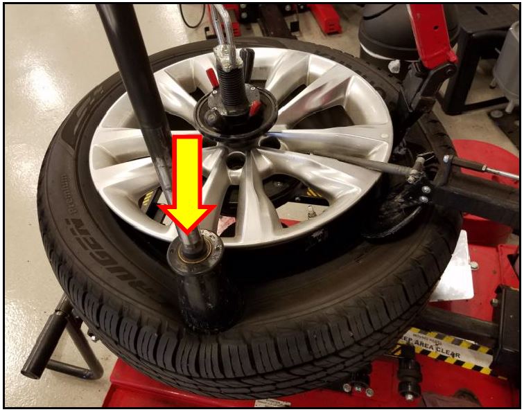 Position the tire depressor on the opposite side of the dismounting head