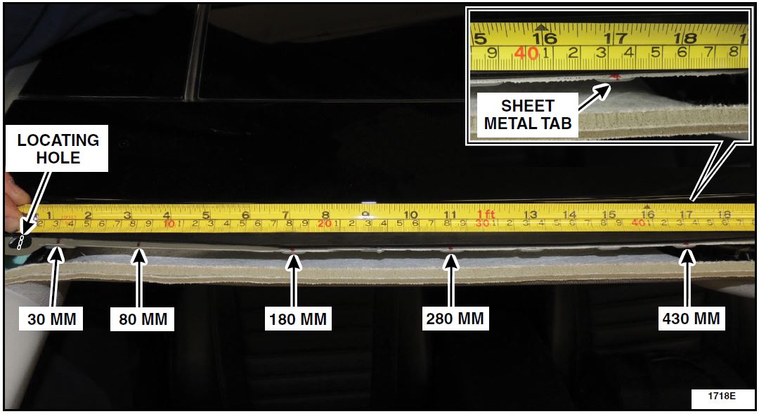 Using a metric tape measure or rule, measure the distance from the center of the locating holes at both the left and right top corners of the windshield opening inward