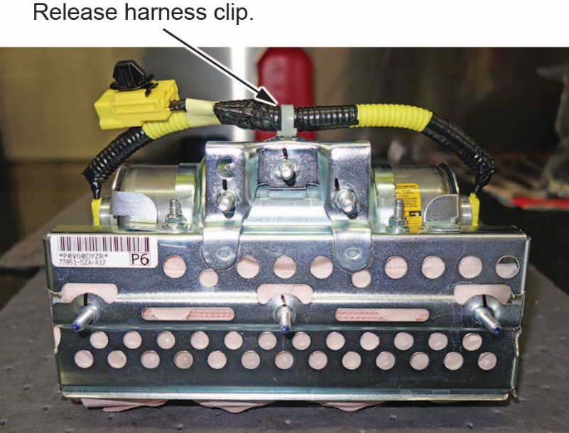 Remove the harness from both ends of the inflator bracket