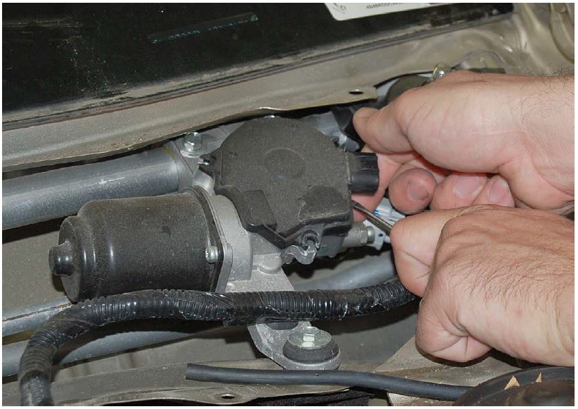 Lift up slightly (Do Not Remove) the right side of the wiper motor bottom cover